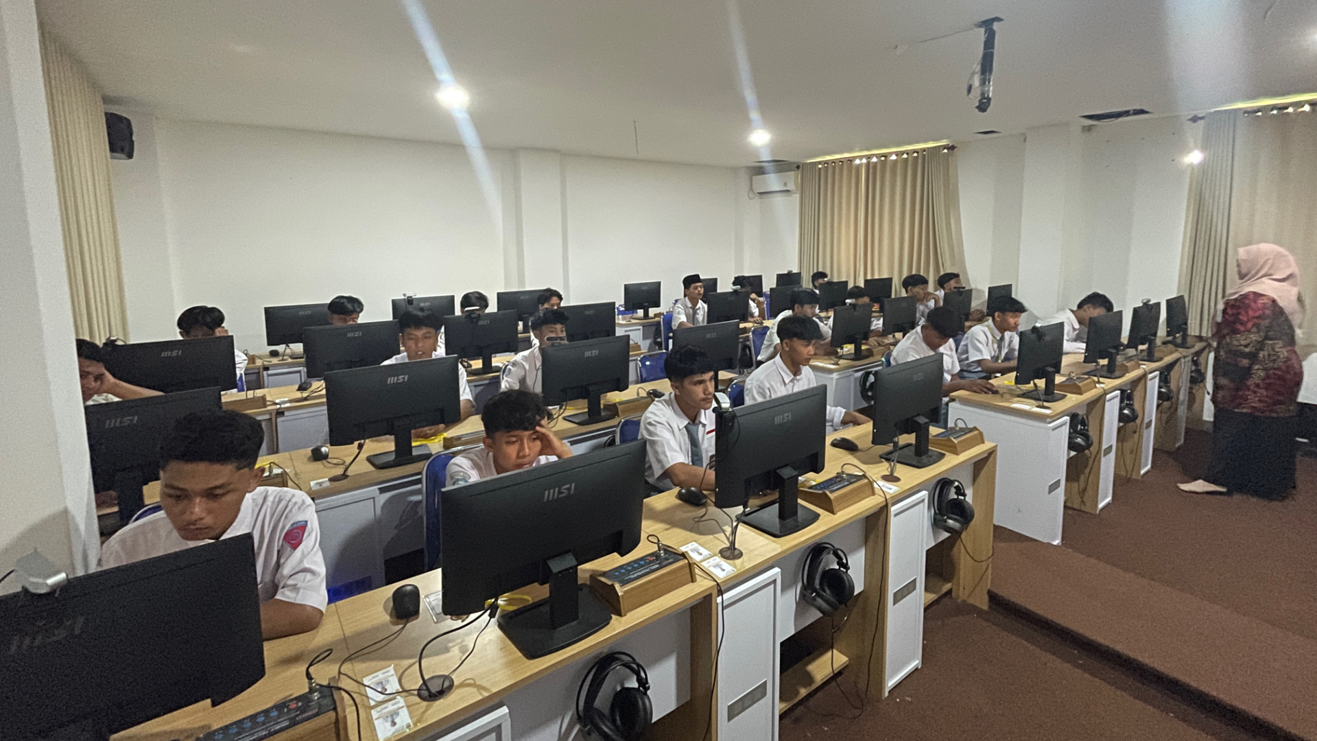 A group of people sitting at computersAI-generated content may be incorrect.